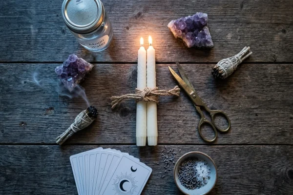 Two burning candles tied with a black string against a starry night sky.