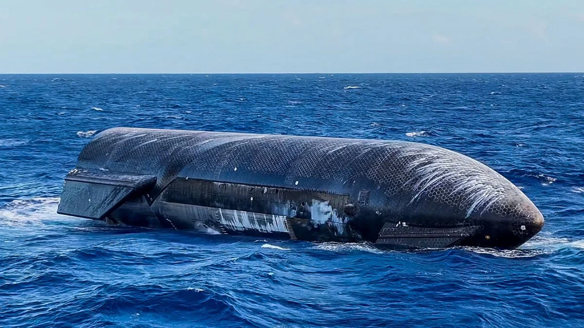 a large black cylinder with wing-like canards floats on top of a choppy blue sea