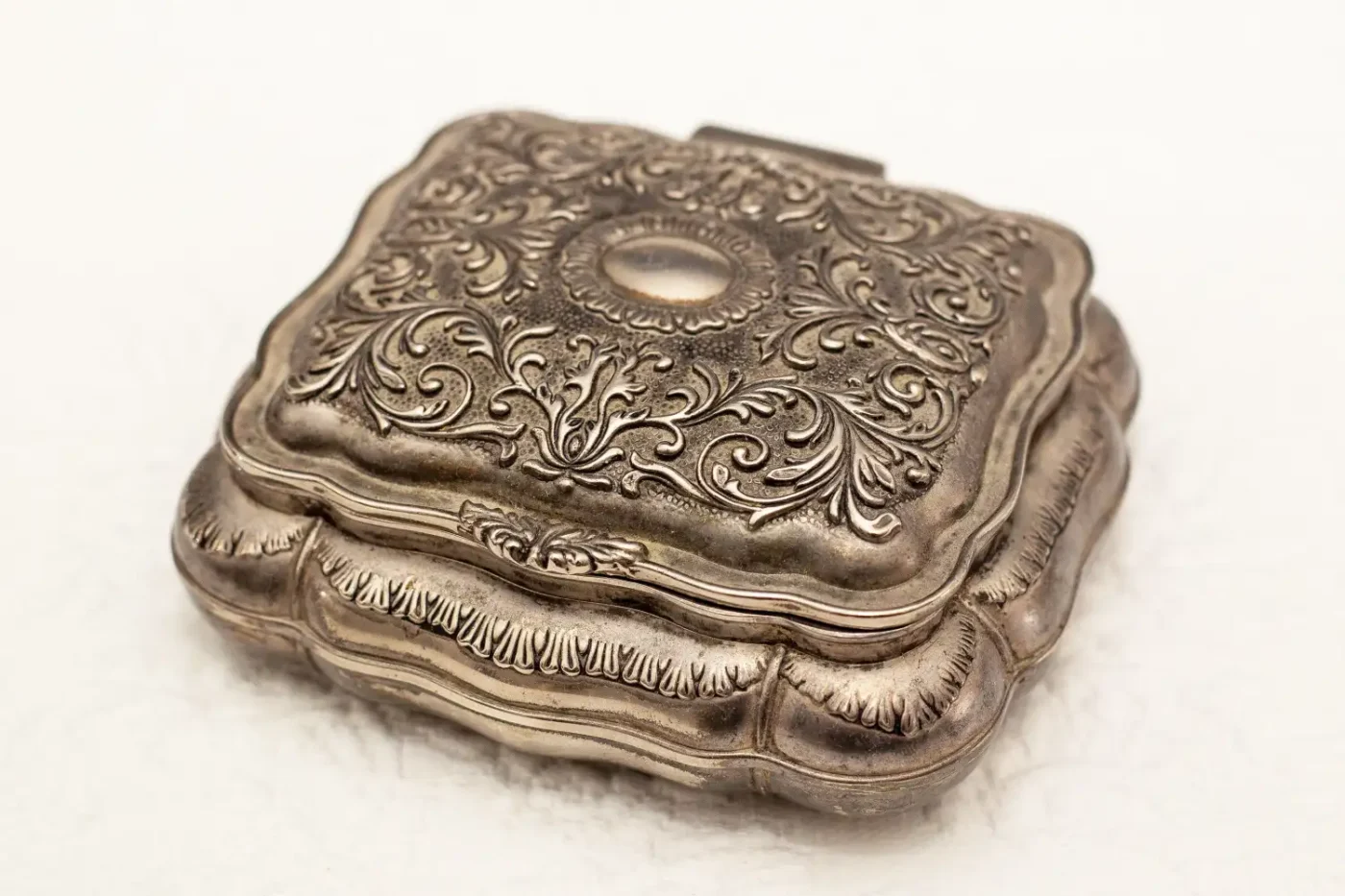 An ornate metal box with detailed engravings rectangular with rounded edges