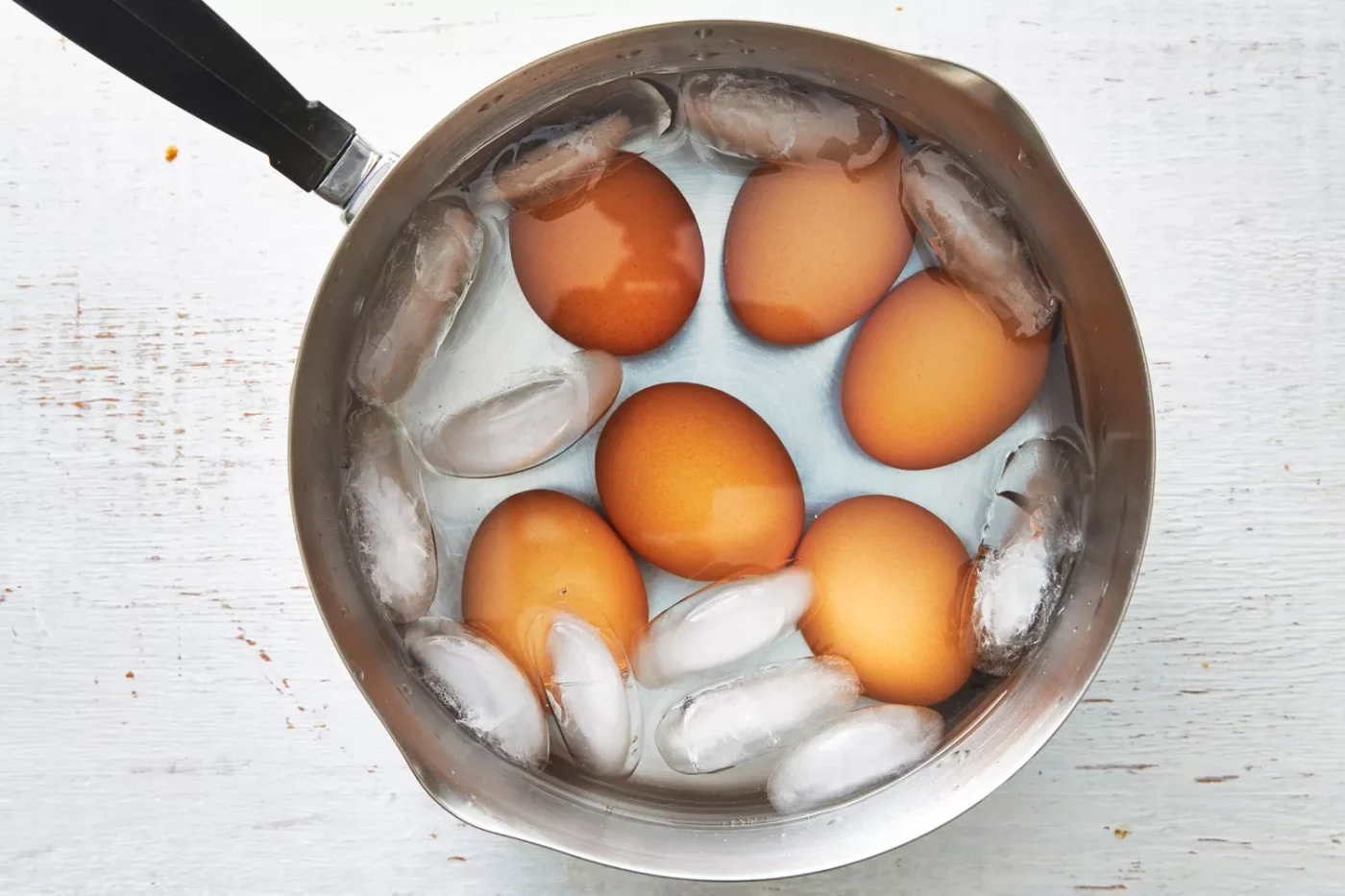 hard boiled eggs in saucepan with ice