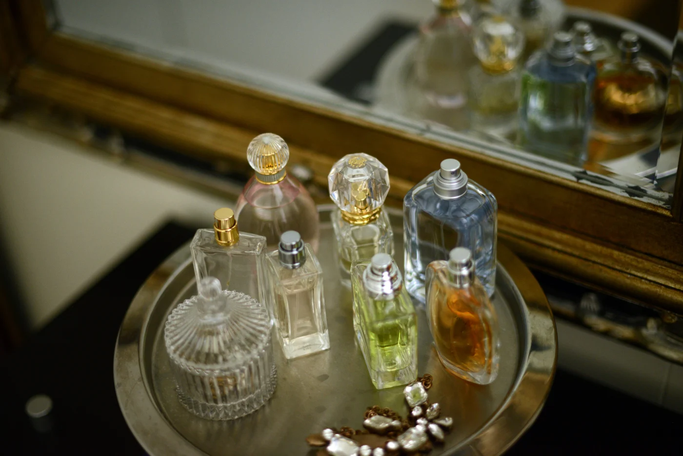 Perfume bottles on a tray by a mirror