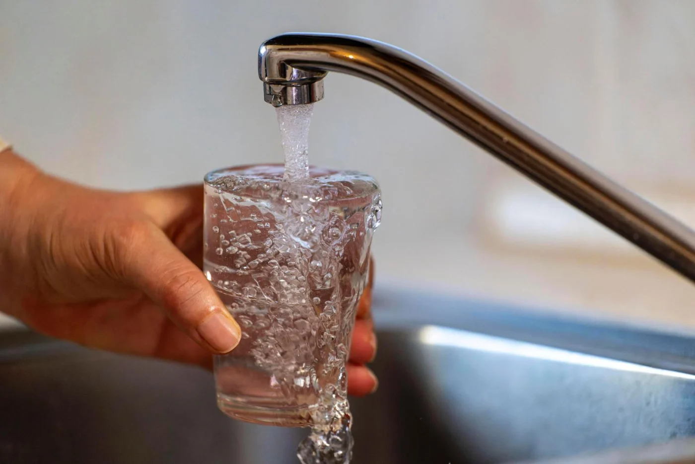 03.01.2024, Trinkwasser läuft aus dem Wasserhahn in einer Küche in Bad Wörishofen (Bayern) in ein Glas. 03.01.2024, Wass