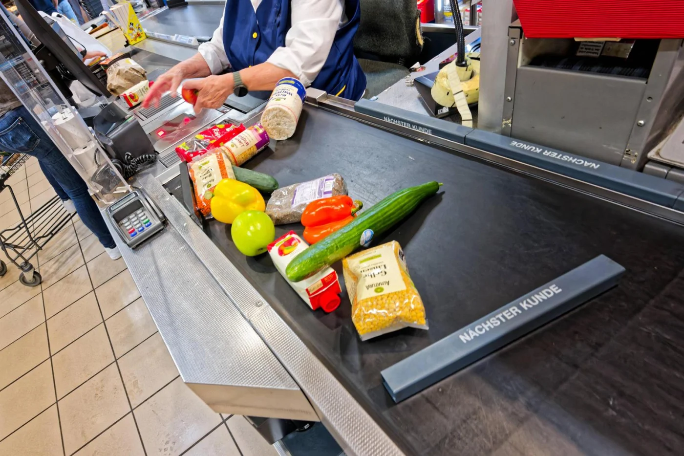An der Kasse. Die Kundin beim Bezahlen im Supermarkt.