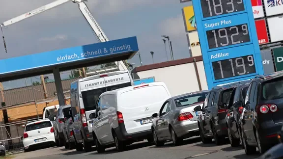 Autos stehen an einer Tankstelle Schlange.