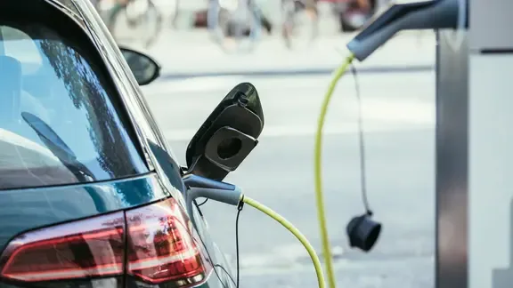 Ein E-Auto tankt Strom an einer Ladesäule.