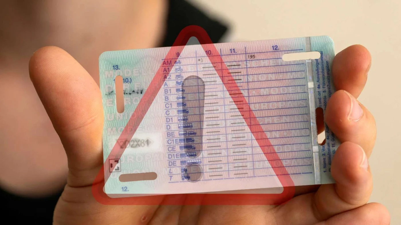 Eine Frau hält einen Führerschein in die Kamera.