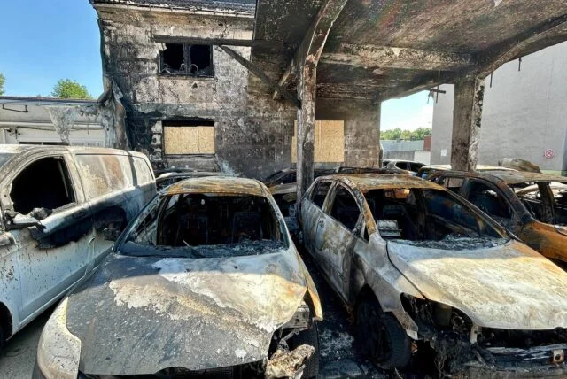 Mehrere ausgebrannte Autos stehen in der durch einen Brand stark beschädigten Kfz-Werkstatt „Kfz Deniz“ in Lünen. Die Karosserien der Fahrzeuge sind verkohlt, während die Wände und Decken großflächige Brandspuren zeigen.